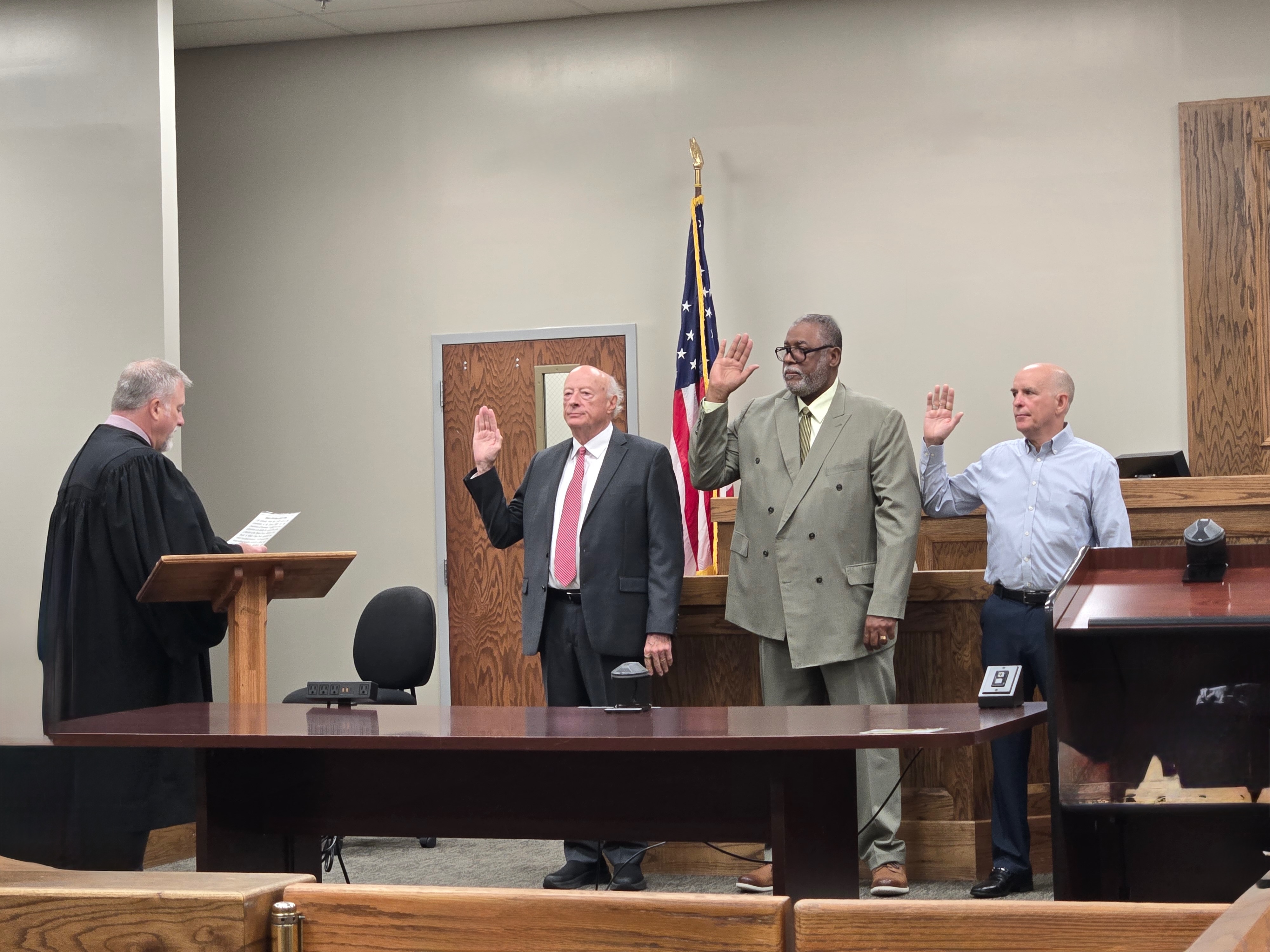 View of the swearing-in ceremony from the audience perspective, showing over 30 attendees in the courtroom gallery